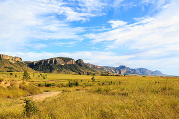 Rocky mountain formation seen from a green valley on a sunny day