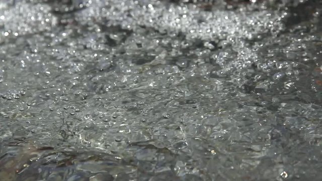 Detalle de burbujas del agua que brotan y fluyen en un  arroyo de agua clara y transparente
