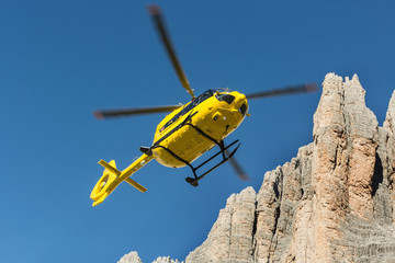  Medical rescue helicopter flying rescue injured climber on the Tre Cime. Italy, Dolomites