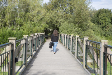Woman Walking on Wooden Bridge