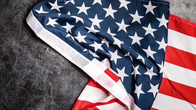 USA flag unrolling on grey background, stop motion animation