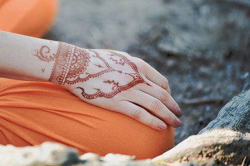 Hand yoga with brown henna mehendi. Harmony and tranquility