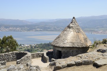 Fototapeta na wymiar Celtic house and the Minho river in Galicia, Spain