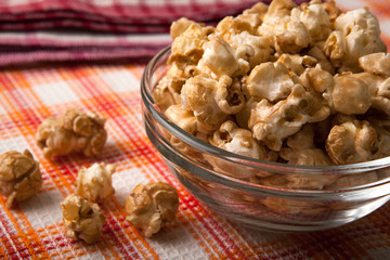 caramel popcorn in a glass bowl on a napkin