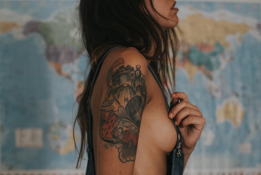 Close-up of tattooed woman with denim cloth on topless body