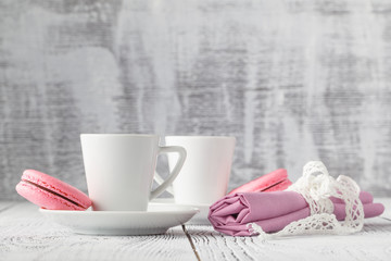 Two cups of black coffee with a delicious macaroons