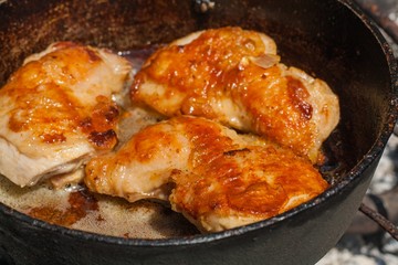 Chicken with spice on frying pan . Chicken frying in a pan . The fried chicken to a gold crust. Food for the weekend outdoors 