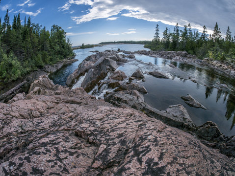 extreme wide angle shot of river draining into lake, quartz rock in foreground