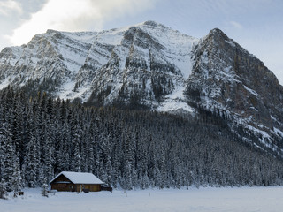 Fototapeta premium Lodge with mountains in winter snow, Lake Louise, Banff National