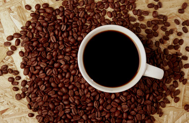 Hot coffee with beans on wooden texture