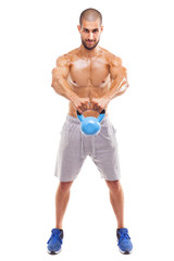 Fototapeta na wymiar Young fit man lifting a kettlebell, isolated on white background