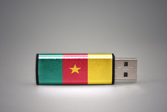 usb flash drive with the national flag of cameroon on gray background.