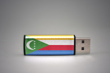 usb flash drive with the national flag of comoros on gray background.
