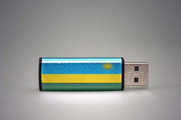 usb flash drive with the national flag of rwanda on gray background.