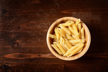 pasta in a  wooden bowl on dark wooden table