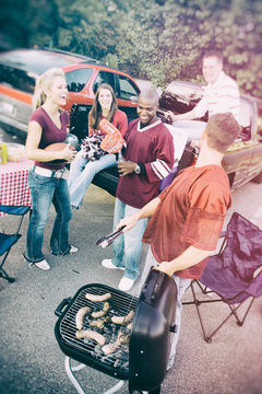 Tailgating: Group Waits As Guy Cooks Sausages