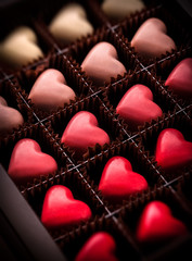 Pralines heart shaped closeup gradually colored in luxury brown box package