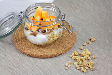 Muesli with papaya and yogurt on a napkin. Healthy breakfast