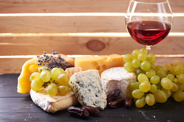 Glass of red wine, served with grapes and cheese