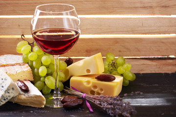 Glass of red wine, served with grapes and cheese