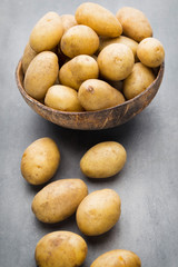 New potato on the bowl, gray background.