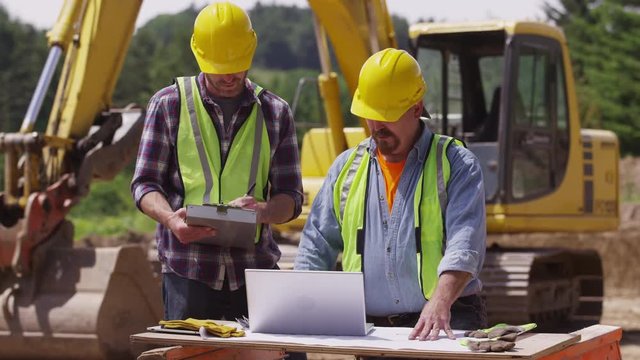 Construction workers using laptop computer