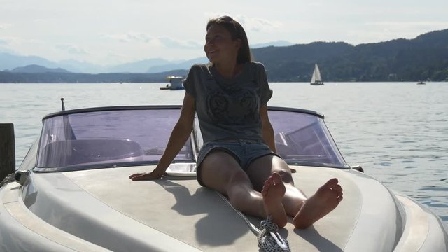 Relaxing on bow of motorboat in mountain lake