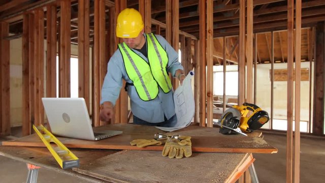 Construction worker looking at home plans