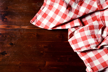 Obraz premium top view of checkered napkin on wooden table