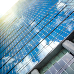 Modern glass hi-rise building skyscraper over bright sky