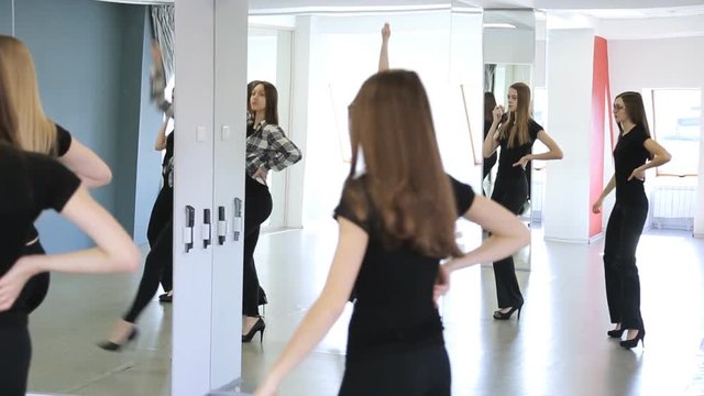 Group of female models in black are learning dance