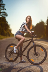 Naklejka na ściany i meble girl on a bicycle at sunset