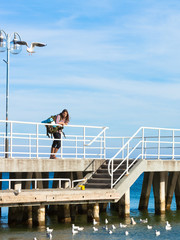 Man hiker with backpack on pier, sea landscape