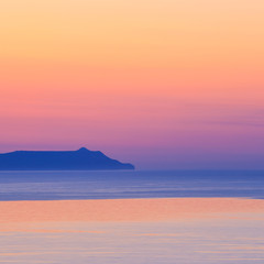 sunset over the mountain with reflection on the sea