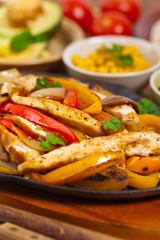 Chicken Fajitas with Grilled Onions and Bell Peppers serve with Tortillas. Selective focus.