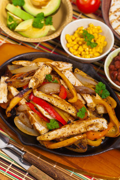 Chicken Fajitas with Grilled Onions and Bell Peppers serve with Tortillas. Selective focus.