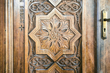 Carved relief folk ornament on wooden door church 