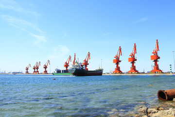 In freight terminal, gantry crane and cargo ships are in loading