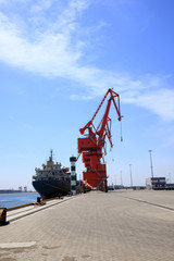 Fototapeta na wymiar In freight terminal, gantry crane and cargo ships are in loading