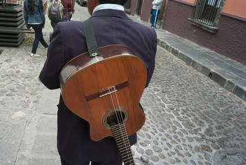 Rear view of a man with guitar on a street, San Miguel de Allend