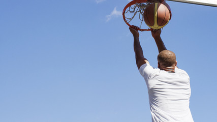 Basketball player slam dunks the ball © icsnaps