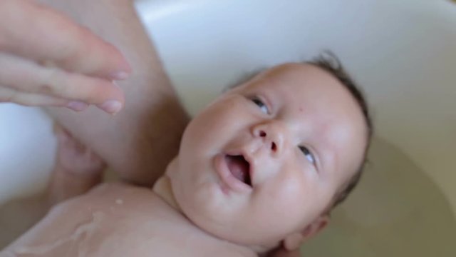 Father is washing happy baby
