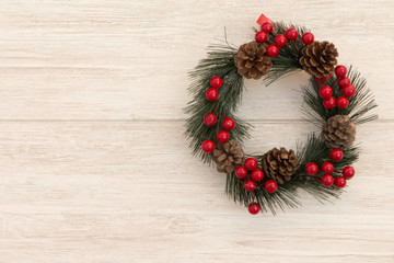 Christmas wreath with pine cones and red berries.