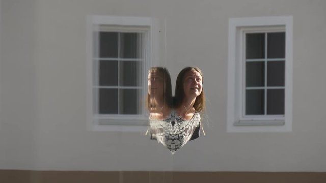 Woman looking out of the corner of mirror wall