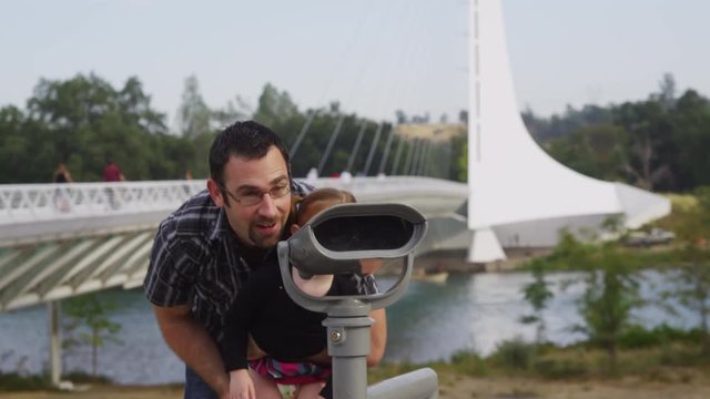 Father and daughter looking through viewer at Sundial Bridge: Redding, California