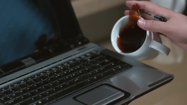 Spilling coffee on laptop computer slow motion; shot on Phantom Flex 4K at 1000 fps