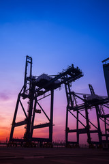Fototapeta na wymiar Cargo port in the evening，The silhouette of gantry crane