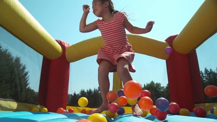 Girl bouncing in inflatable play house, super slow motion - Powered by Adobe