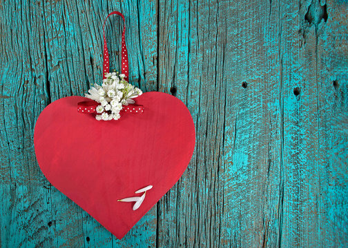 red wooden heart with daisies on turquoise painted barn wood