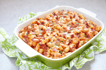 Pasta casserole with bacon, ham, cheese and tomato